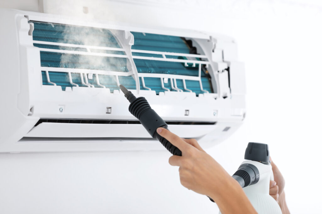 Technician cleaning air conditioner indoors